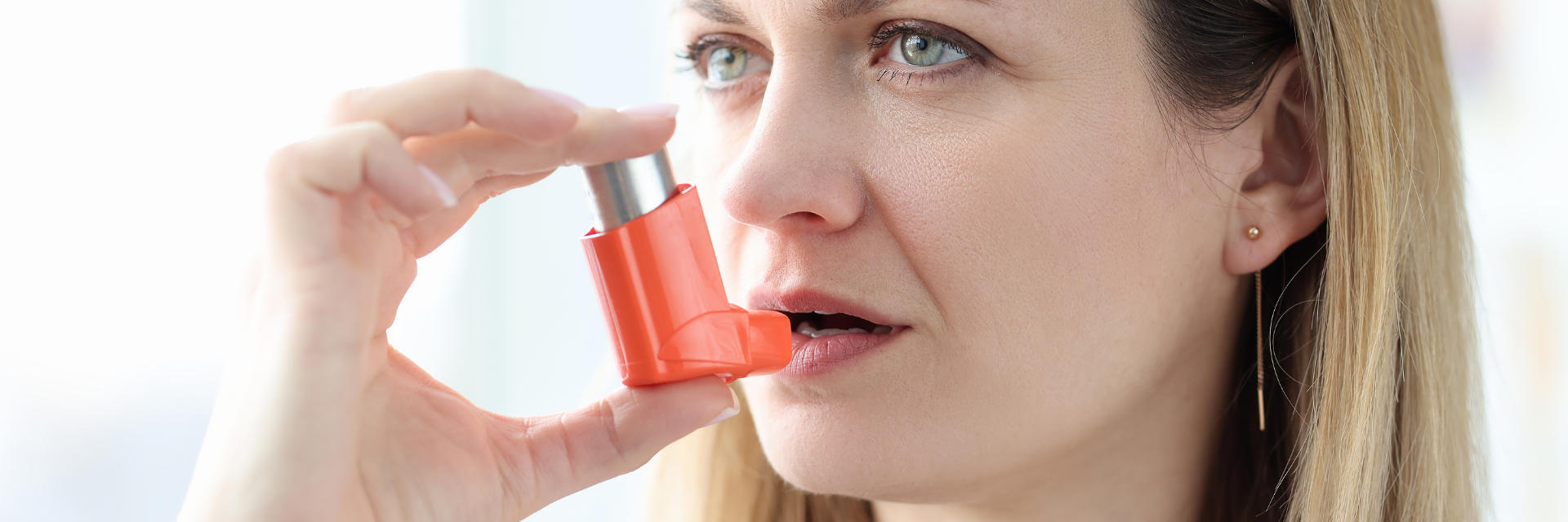 A woman using a reliever inhaler.