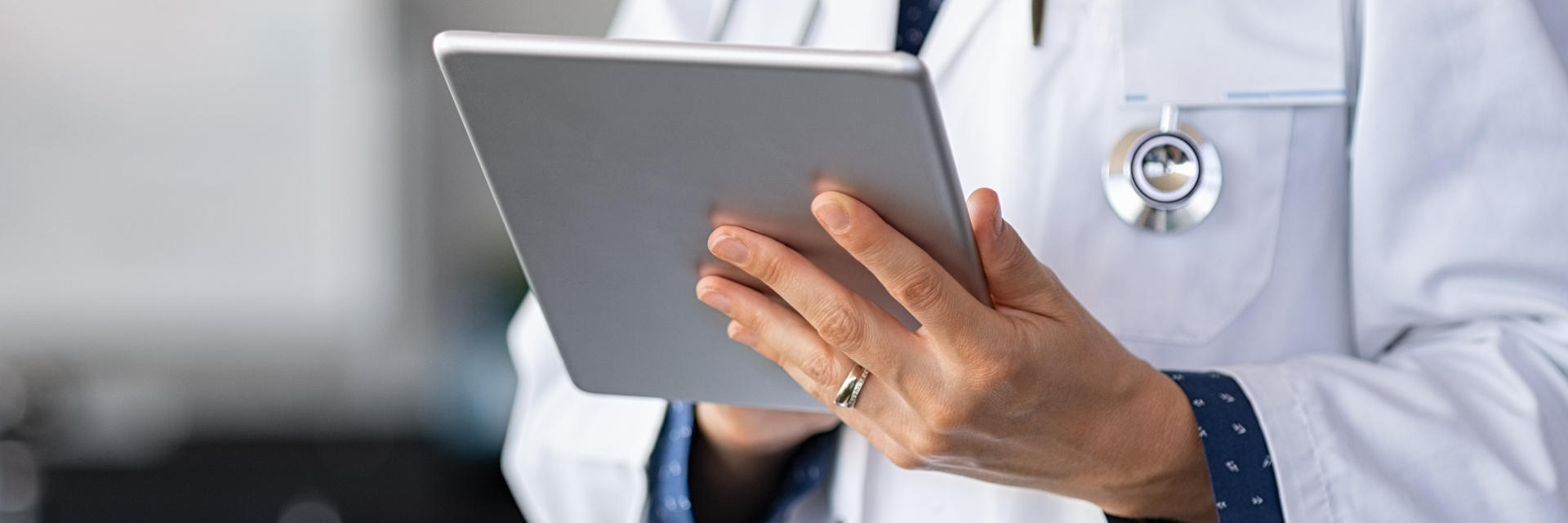 Primary care physician checking medical records on a tablet.